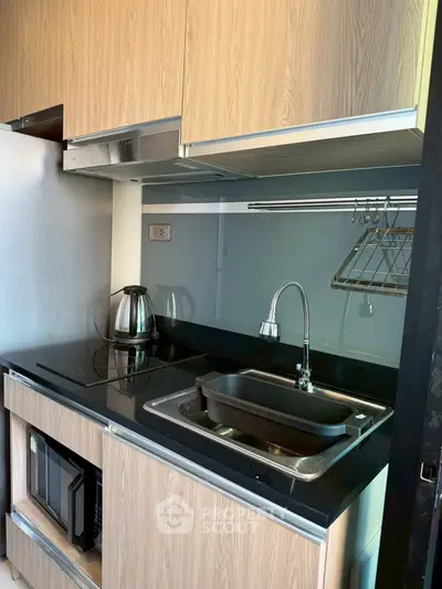 Modern compact kitchen with sleek cabinetry and stainless steel appliances