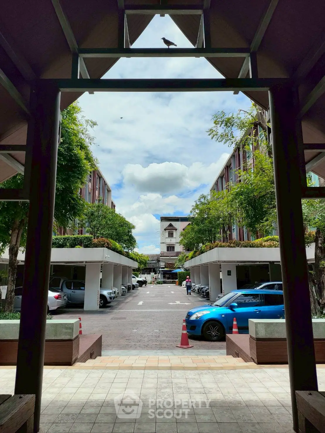 Charming residential complex with lush greenery and ample parking space.