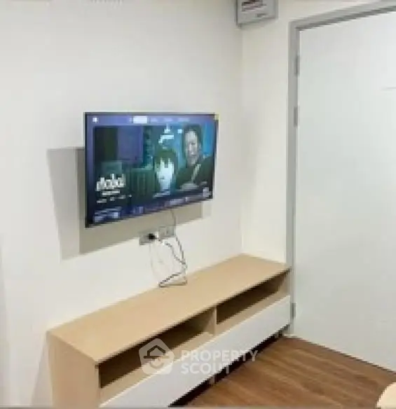 Modern living room with wall-mounted TV and sleek wooden cabinet