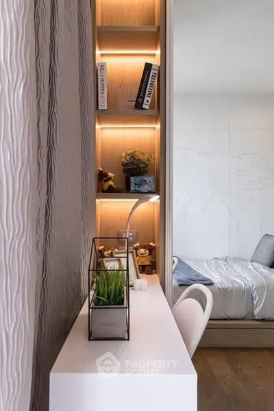 Modern study area with sleek desk and built-in shelving in stylish bedroom.
