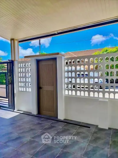 Charming outdoor patio with stylish privacy wall and sleek tiled flooring, perfect for relaxation.