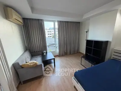 Spacious bedroom with modern furnishings and large window offering city views.