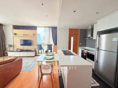 Modern open-plan living room and kitchen with city view, featuring sleek appliances and stylish decor.