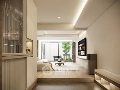 Modern living room with sleek design and natural light, featuring a large TV and comfortable seating.