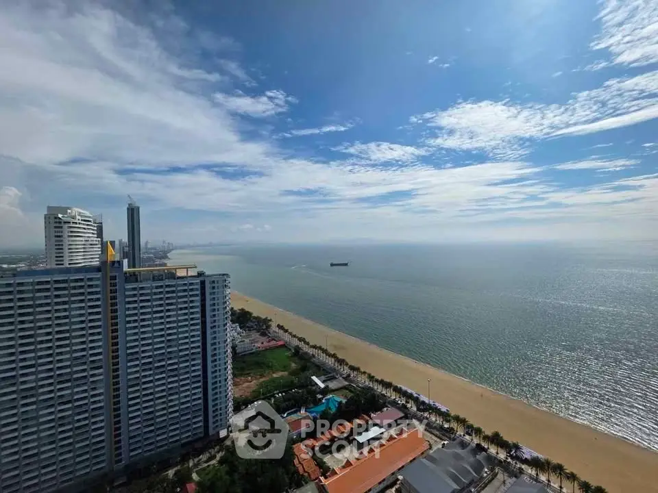 Stunning beachfront view from high-rise building with expansive ocean and skyline panorama.