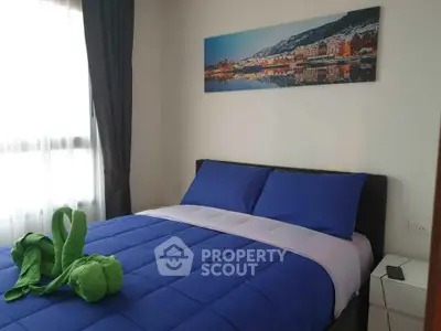 Cozy bedroom with blue bedding and scenic wall art