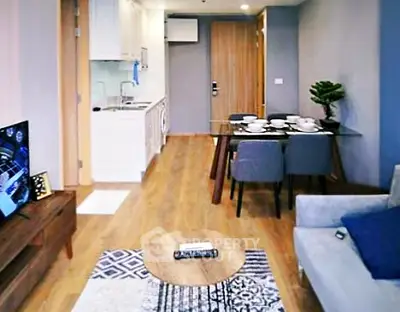 Modern open-plan living room with dining area and kitchen in stylish apartment.