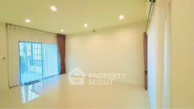 Spacious living room with large windows and elegant curtains, perfect for natural light and modern living.