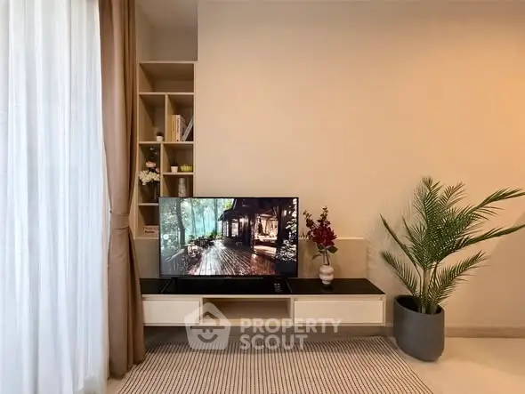 Modern living room with TV, elegant decor, and natural light
