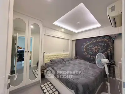 Modern bedroom with stylish decor and mirrored wardrobe doors