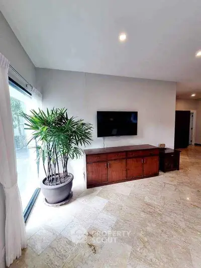 Spacious living room with modern TV setup and elegant marble flooring