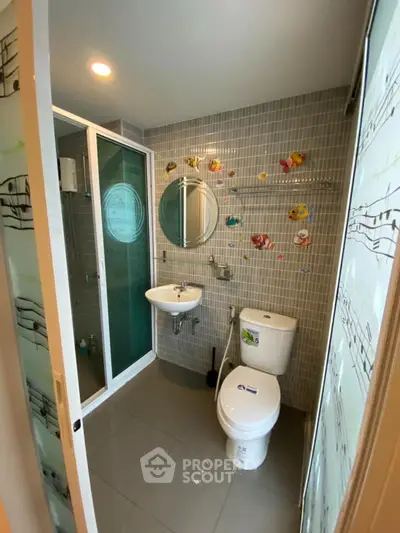 Modern bathroom with shower, toilet, and musical-themed decor.