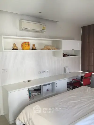 Modern bedroom with sleek white furniture and air conditioning, ideal for comfort and style.