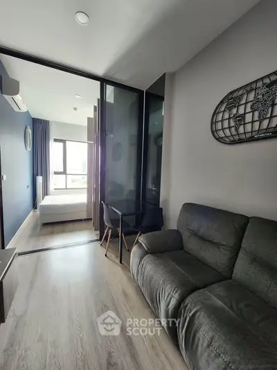 Modern apartment interior with cozy living room and bedroom view, featuring stylish decor and natural light.