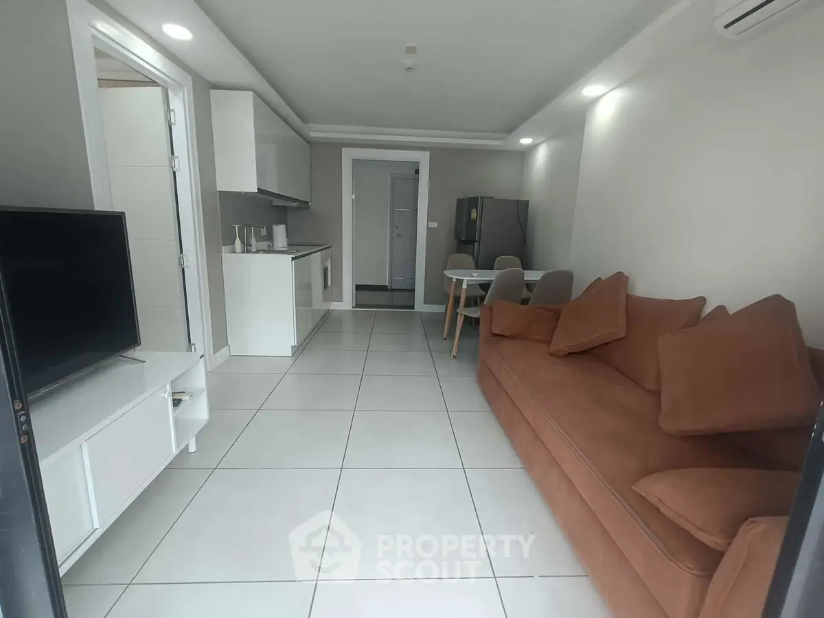 Modern open-plan living room with sleek kitchen and cozy sofa, perfect for urban living.