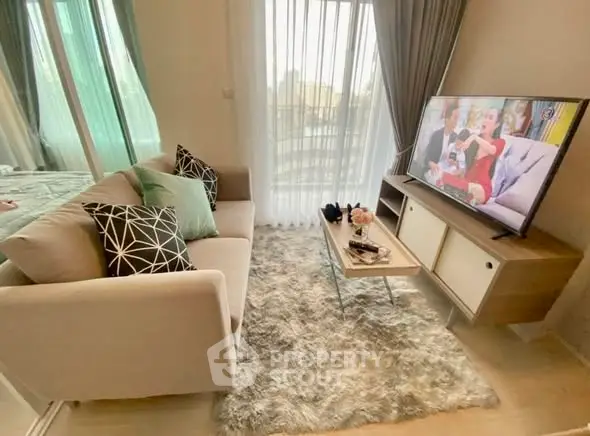 Cozy living room with plush sofa, stylish decor, and large TV, perfect for relaxation.