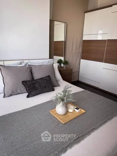 Modern bedroom with stylish decor and cozy ambiance, featuring a sleek wardrobe and elegant bedding.
