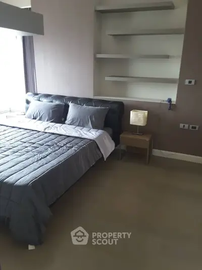 Modern bedroom with sleek design, featuring a stylish bed and built-in shelves, perfect for urban living.