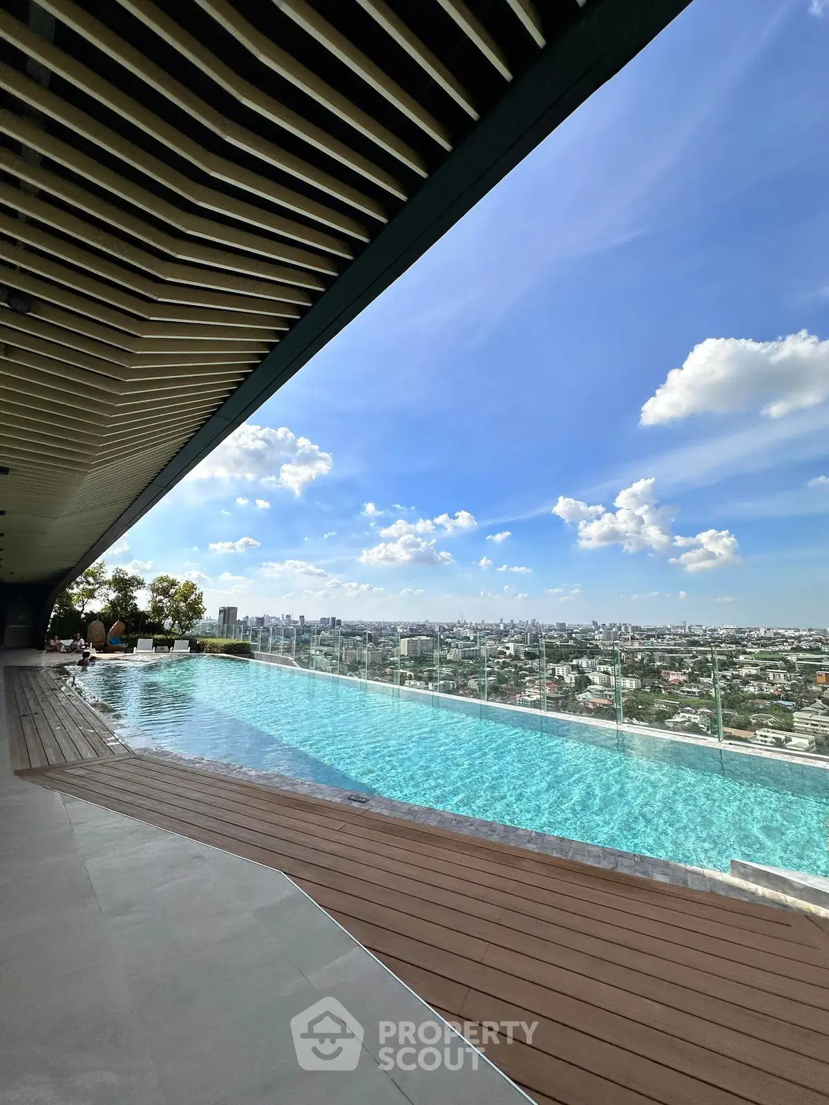 Stunning rooftop pool with panoramic city views under a clear blue sky.