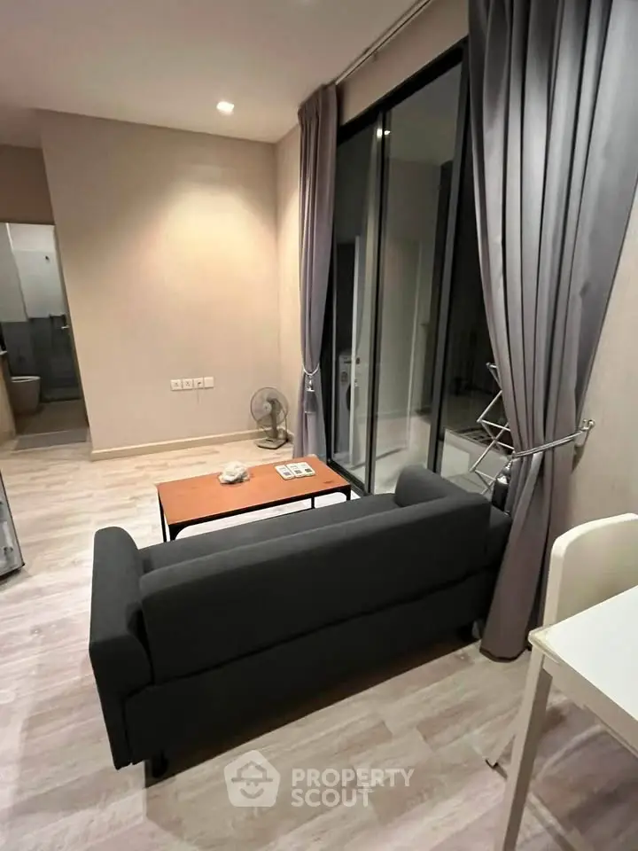 Modern living room with sleek sofa and floor-to-ceiling windows in a stylish apartment.