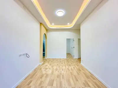 Spacious modern living room with elegant ceiling lights and wooden flooring.