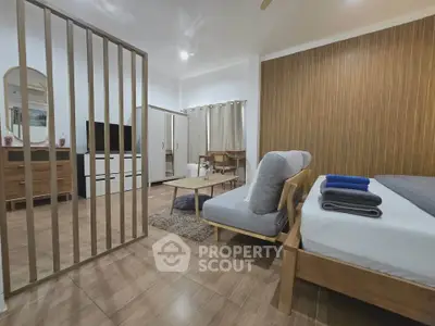 Modern studio apartment with stylish wooden accents and cozy furnishings.