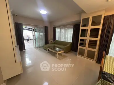 Spacious living room with green sofa and large windows for natural light