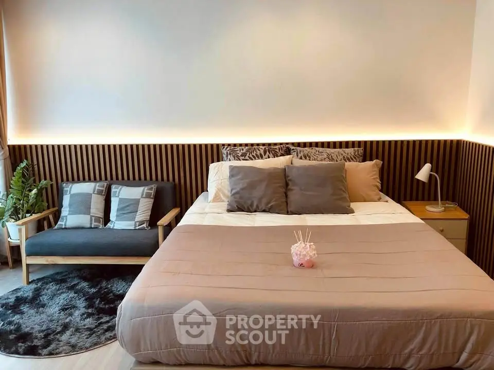 Stylish bedroom with modern decor and cozy lighting, featuring a comfortable bed and chic seating area.