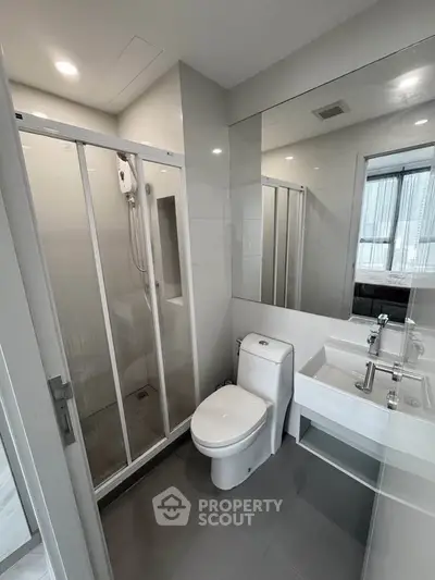 Modern bathroom with glass shower and sleek fixtures in a contemporary apartment.