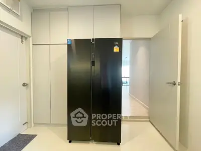 Modern kitchen with sleek black refrigerator and minimalist design