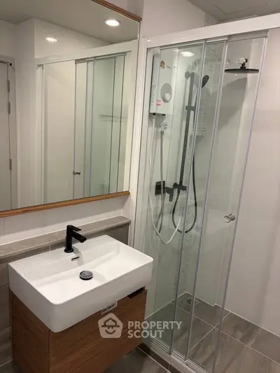 Modern bathroom with sleek shower and stylish vanity in contemporary apartment.