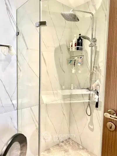 Modern bathroom with glass shower enclosure and marble tiles