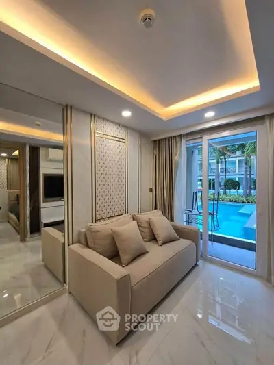 Luxurious living room with pool view, elegant lighting, and modern decor.