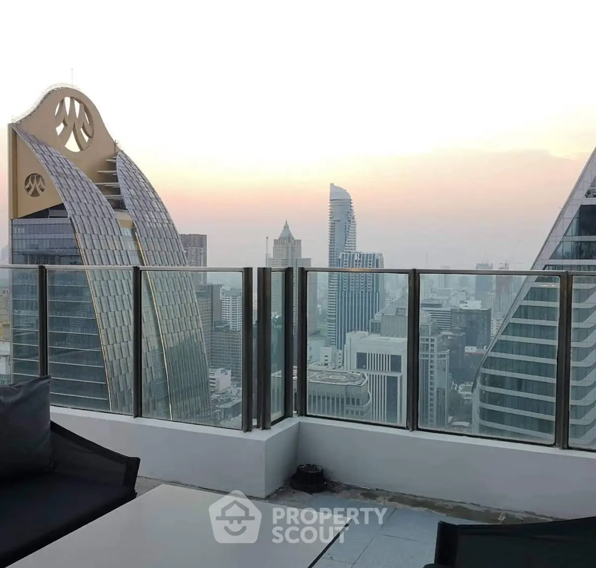 Stunning cityscape view from a modern high-rise balcony at sunset.