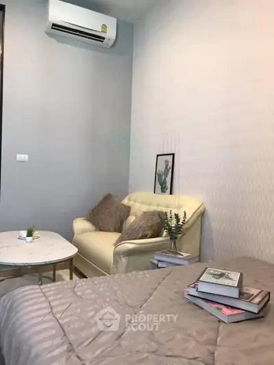 Cozy bedroom with air conditioning and stylish decor, featuring a comfortable sofa and modern furnishings.