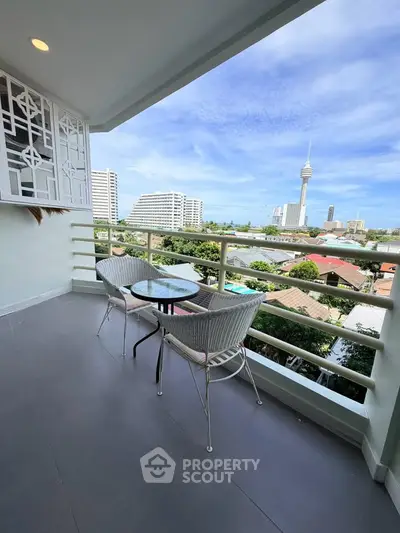 Spacious balcony with stunning city view and cozy seating area, perfect for relaxation.
