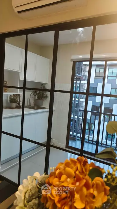 Modern kitchen with open layout and balcony view in urban apartment