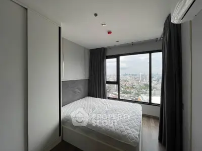 Modern bedroom with large window offering stunning city views, featuring sleek design and cozy ambiance.