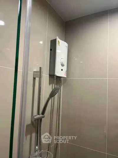Modern bathroom with sleek shower and water heater in contemporary design.