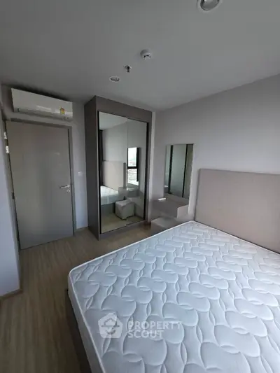 Modern bedroom with mirrored wardrobe and air conditioning unit