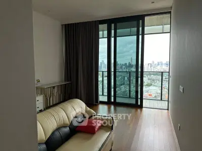 Modern living room with city view and large balcony, featuring sleek furniture and floor-to-ceiling windows.