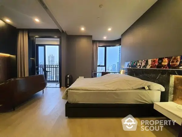 Spacious bedroom with modern design, king-sized bed, and access to a private balcony boasting a panoramic city view, ideal for urban living.