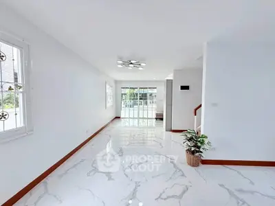 Spacious modern living room with marble flooring and large windows for natural light.