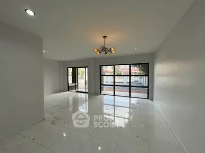 Spacious modern living room with large windows and elegant lighting, perfect for natural light and open living.