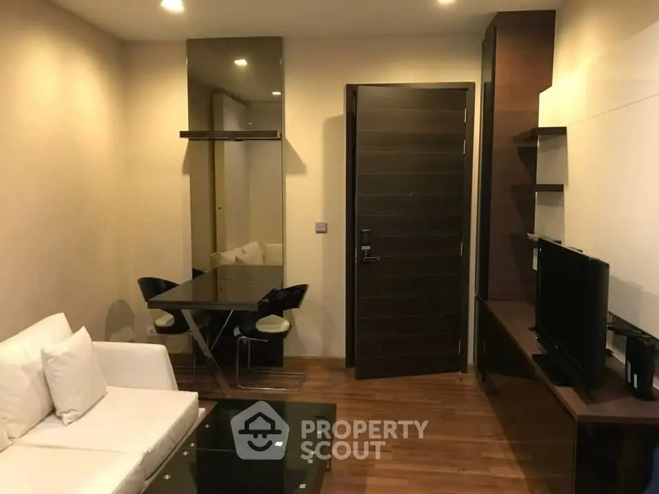 Modern living room with sleek furniture and wooden flooring in a cozy apartment.