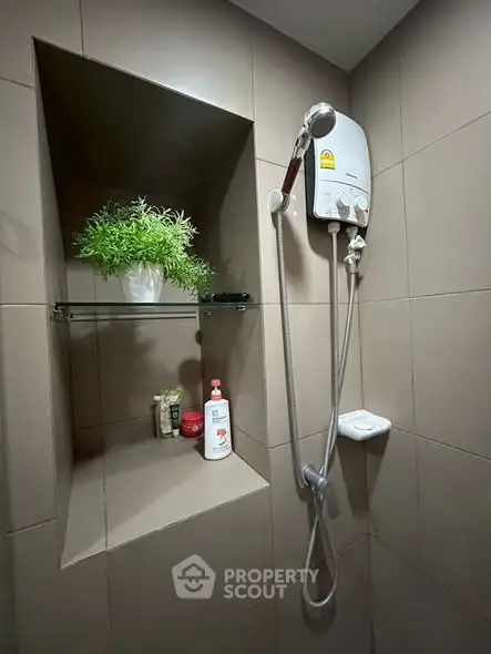 Modern bathroom with sleek shower and built-in shelf, featuring stylish tile design and contemporary fixtures.