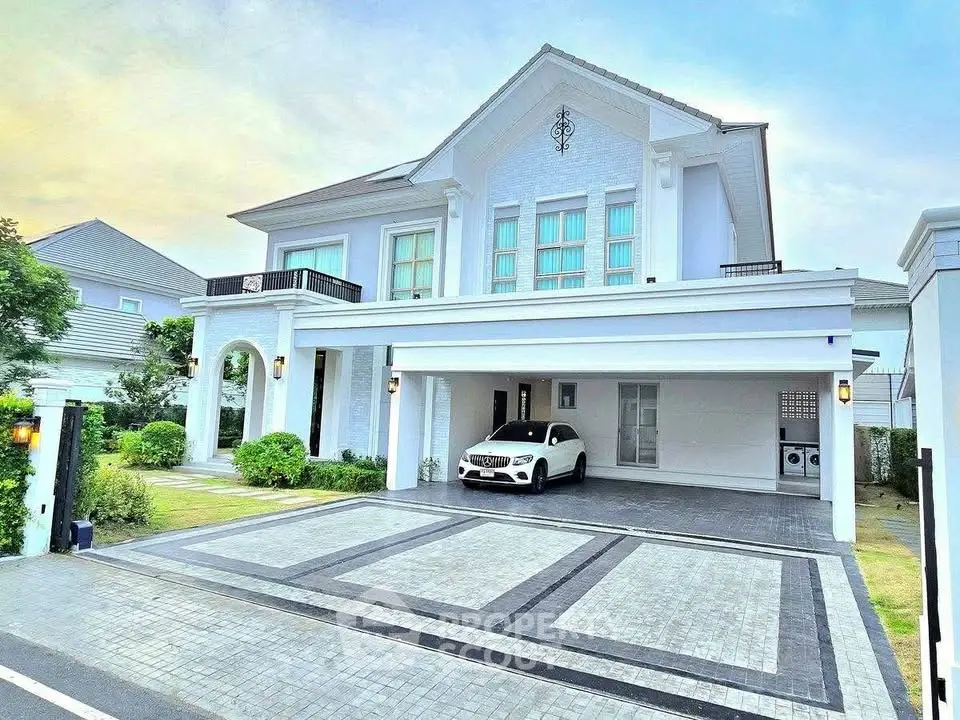 Luxurious modern white villa with spacious driveway and elegant architectural design.