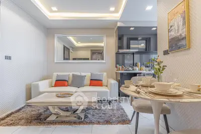 Modern living room with stylish decor and open kitchen layout, featuring a cozy sofa and elegant dining area.
