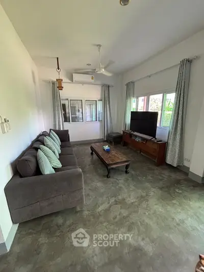 Spacious living room with modern decor and large windows for natural light.