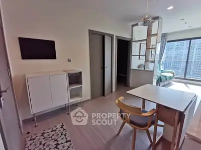 Modern apartment interior with open layout, stylish furniture, and large windows offering city views.